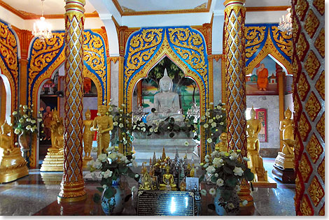 Stille herrscht im Inneren des blumengeschmckten buddhistischen Tempel in Wat Chalong.