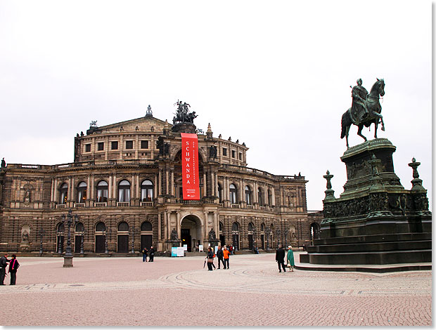Die Semperoper am 
			Theaterplatz in Dresden mit dem Knig-Johann-Denkmal davor.