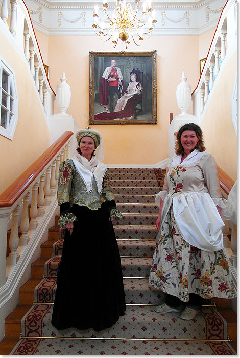 Oben in vollem Ornat in l gemalt: die Besitzer des Schlosses Edgcumbe, unten auf der Treppe Besucher als Dienerinnen verkleidet. 