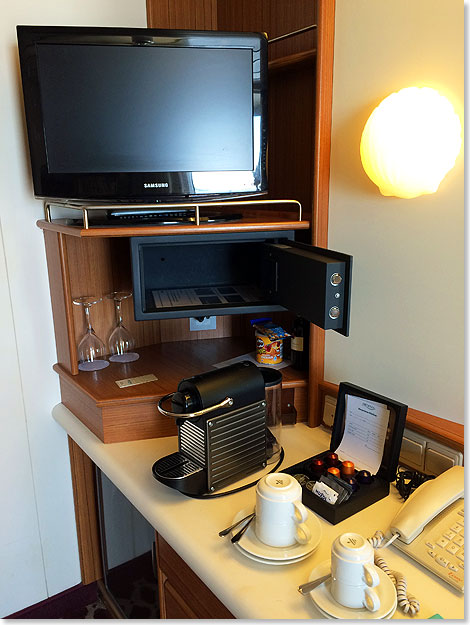 Der Schreibtisch in der Kabine, mit Kaffeemaschine, TV und Safe.