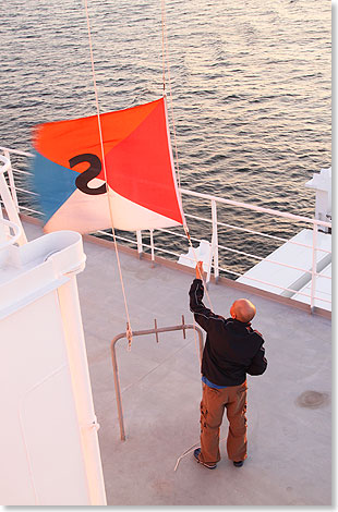 Reedereiflagge wird bei Sonnenuntergang eingeholt