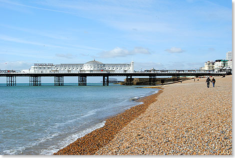 Der Strand von Brighton mit seinem Wahrzeichen, dem Brighton Pier. Ganz hinten die Ruine des West Piers.