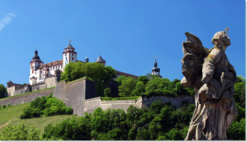 Die Feste Marienberg in Würzburg. Im Vordergrund eine Sandstein-Statue der 
	  Alten Mainbrücke