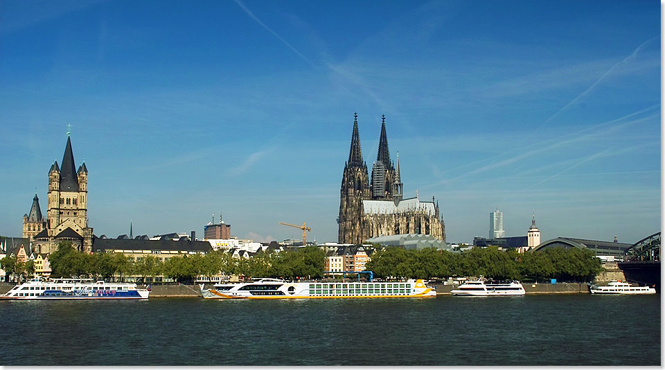 Die romanische Kirche Gro St. Martin und der Dom, rechts davon das Dach des Hauptbahnhofs und ein kleiner Teil der Hohenzollernbrcke. Davor die Anlegestellen der Schiffe in Kln