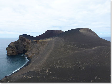 Die schwarze Landspitze steht im Kontrast zur sonst dicht bewachsenen grünen Insel.