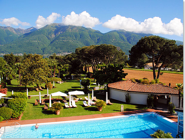 Blick von einem Zimmer des außerhalb von Ascona gelegenen Fünfsterne-Hotels auf Pool, Park, Felder und Berge.