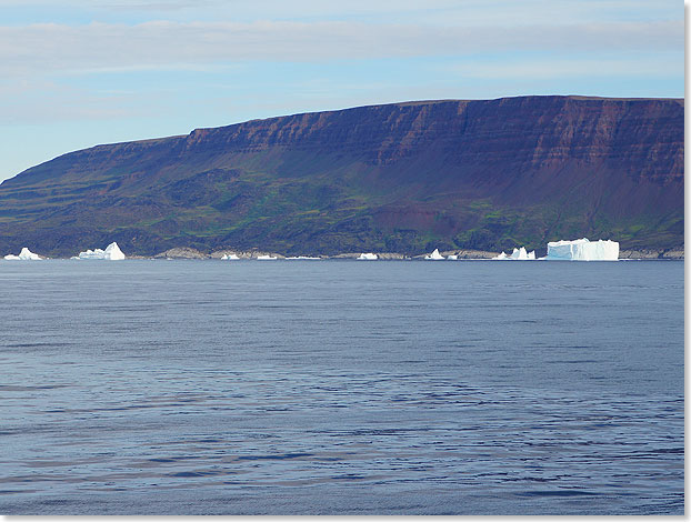  Die Disko Insel kommt näher. Die Eisberge in unmittelbarer Nähe der Küste erscheinen relativ klein, doch das täuscht. Die Höhe des Tafeleisberges ist beachtlich.
