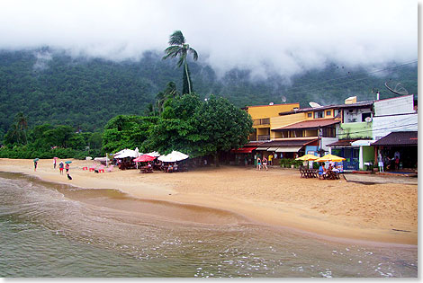 Andere Gäste gehen zur Strandpromenade mit Restaurants in Abraão. 