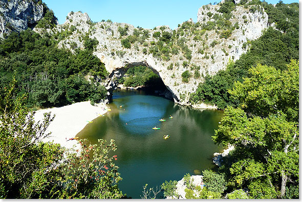 Winzige Paddelboote unter dem Pont d’Arc, dem 34 Meter hohen Bogen ber der Ardeche, die sich tief in die Kalklandschaft eingegraben hat.