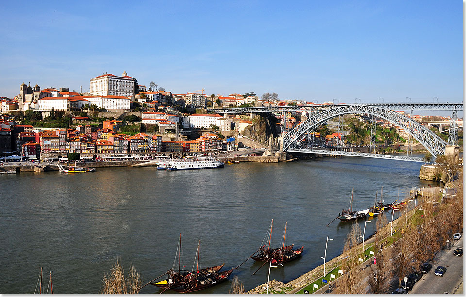 Die Postkarten-Ansicht von Porto mit Blick auf die Brcke Ponte Dom Luis I. und im Vordergrund die alten Transportboote Barcos Rabelos, mit denen einst die 