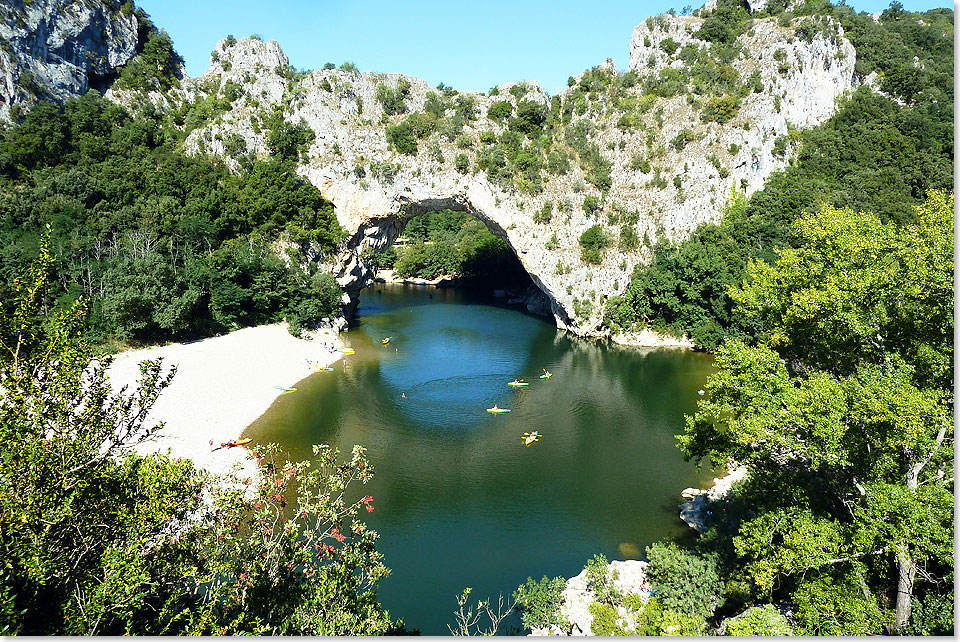 Winzige Paddelboote unter dem Pont dArc, dem 34 Meter hohen Bogen ber der Ardeche, die sich tief in die Kalklandschaft eingegraben hat. 