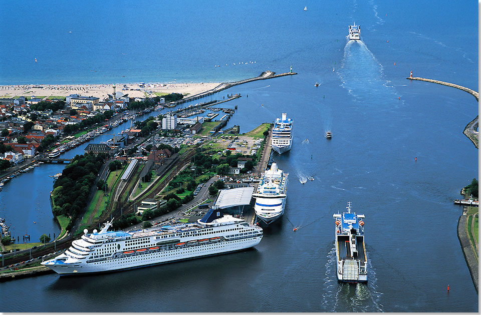 Das Warnemnde Cruise Center mit drei Kreuzfahrtschiffen am Anleger und zwei auslaufenden Fhrschiffen.