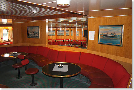 Die achtere Bar der LOFOTEN ist mit ihren warmen Farbtönen und den historischen Schiffsbildern an der Wand ein Kleinod der Gemütlichkeit.  