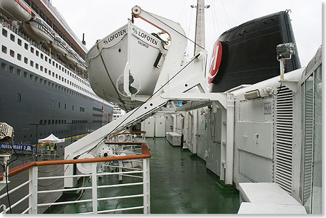 Auf dem Bootsdeck der LOFOTEN. Am Kai gegenber ragt die Bordwand der riesigen QUEEN MARY 2 einem Hochhaus gleich in den Himmel. 