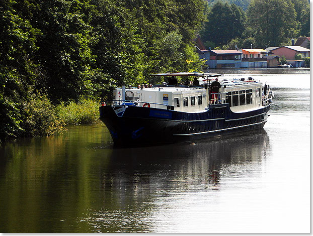 In langsamer Fahrt mit abgesenktem Steuerhaus und flachgelegter Reling auf dem Oberdeck nhert sich die 