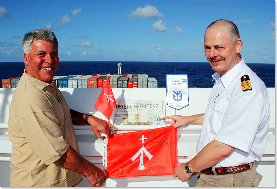 Dr. Peer Schmidt-Walther überreicht Kapitän Udo Wölms vor Mauritius die Stralsund-Flaggen.