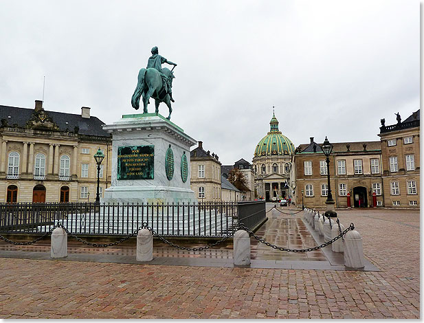 Schloss Amalienborg in Kopenhagen besteht aus vier fast baugleichen Palais und ist Sitz der dnischen Knigsfamilie, der ltesten Monarchie der Welt. Das Standbild zeigt Frederik V. (1723 bis 1766), der den Stadtteil Frederiksstaden begrndete und dem Lande Frieden und Wohlstand brachte. Im Hintergrund die Marmorkirche.