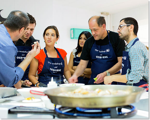 Eine Gruppe lernt Paella kochen in The Workshop in Valencia.