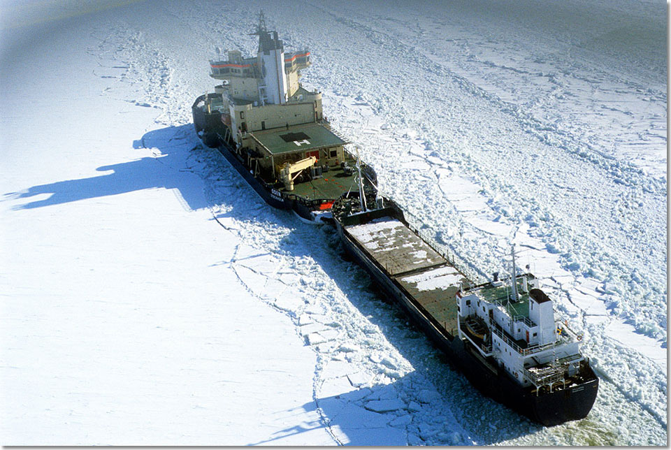 Ein Frachter wird im Koppelverband durchs Eis geschleppt.