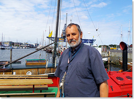 Der Vorsitzende des Museumshafens Rostock e.V., Hans-Peter Wenzel vor der Kulisse des Museumshafens. 