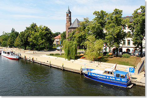 Im Hintergrund Brandenburgs Blumenkirche  im blauen Boot ist die Flussschifferkirche in Berlin untergebracht.
