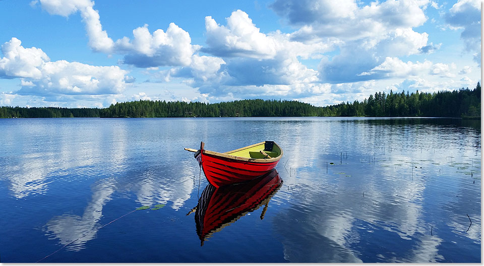 Rotes Ruderboot unter Wolkenhimmel auf dem Saimaa-See.