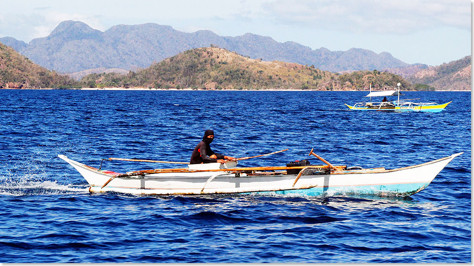 Couron auf Luzon, Philippinen  Ein vor der Sonne geschtzter Einbaum-Fischer, er knnte auch ein Pirat sein.