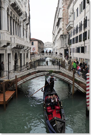 Gondeln erledigen in Venedig das, was sonst Taxis machen  nur sehr viel teurer. Sie knnen auch enge Kanle befahren wie diesen. Im Hintergrund die 