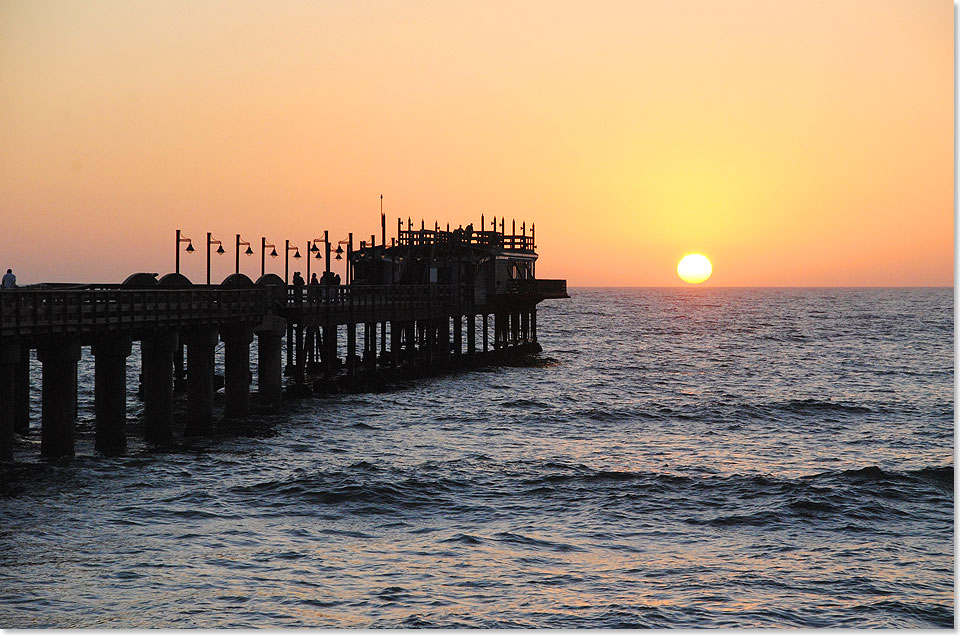 Sonnenuntergang an der historischen Jetty, der ber 300 Meter langen Landungsbrcke von Swakopmund. ber das ursprnglich 1905 aus Holz errichtete Bauwerk wurde whrend der deutschen Kolonialzeit fast der komplette Schiffsgutverkehr, der Deutsch-Sdwestafrika versorgte, abgewickelt.  Spter wurde es durch eine Metallkonstruktion ersetzt. 