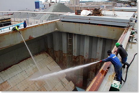 Reinigen der Laderume mit Hochdruck-Wasserstrahlen.