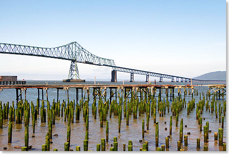 Brücken bauen nach dem Krieg. Diese überspannt die breite Mündung des Columbia Rivers in Astoria. Die Pfähle im Vordergrund sind Überbleibsel aus dem alten Hafen, der im Zweiten Weltkrieg einer der bedeutendsten der amerikanischen Westküste war.