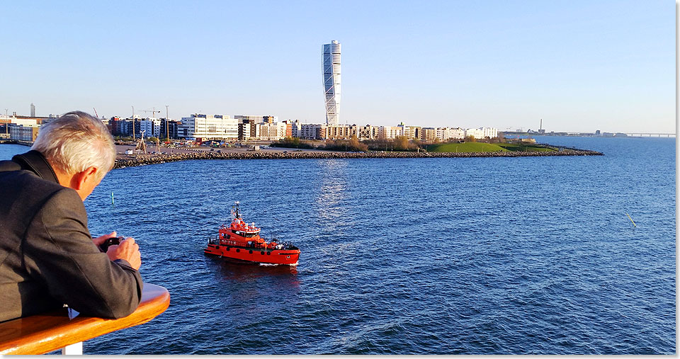 Das Lotsenboot läuft während des Auslaufens aus Malmö neben dem Schiff her.