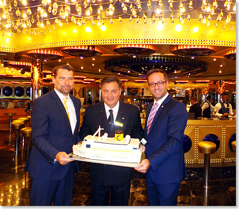 Das Foto zeigt, von links, Jens-Aurel Scharner (HERO-Geschftsfhrer), Kapitn Carmine Maddaloni und Hardy Puls, Director Marketing & Sales von Costa Deutschland mit einer Torte in Form des Schiffes.