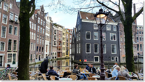 Gut besetztes Restaurant an einem Amsterdamer Kanal.