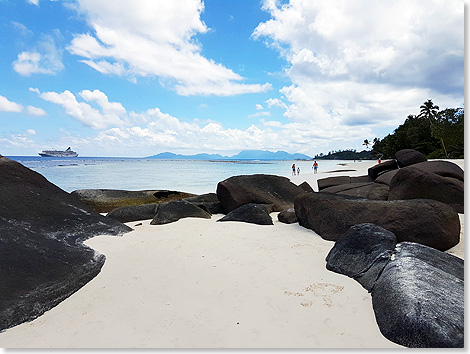 Silhouette Island: MS ARTANIA vor Strand mit Felsenkulisse.