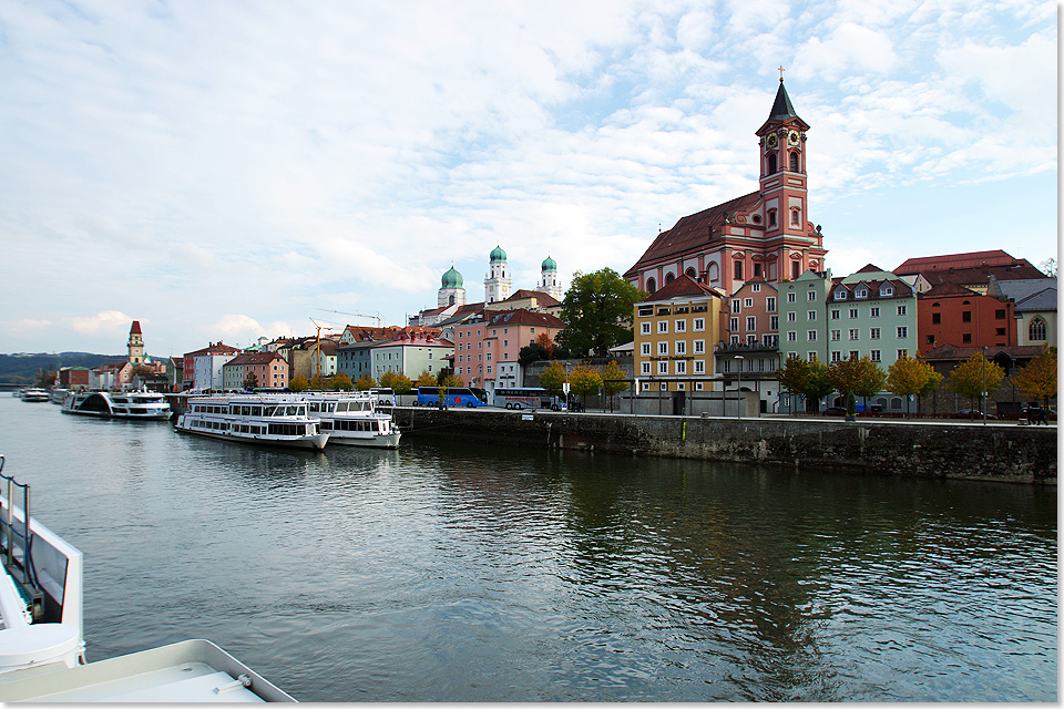 Nachdem MS ARIANA an der Unteren Donaulnde abelegt und gegen den Strom oberhalb der Schanzlbrcke gedeht hat, verlsst das Schiff die Dreiflssestadt Passau. Rechts die Katholische Kirche St. Paul, in der Mitte die Trme vom Dom St. Stephan, links der Turm des Alten Rathauses.