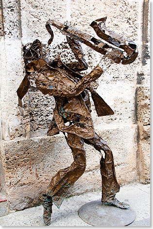 Blech-Skulptur eines Saxophonisten am Straßenrand.