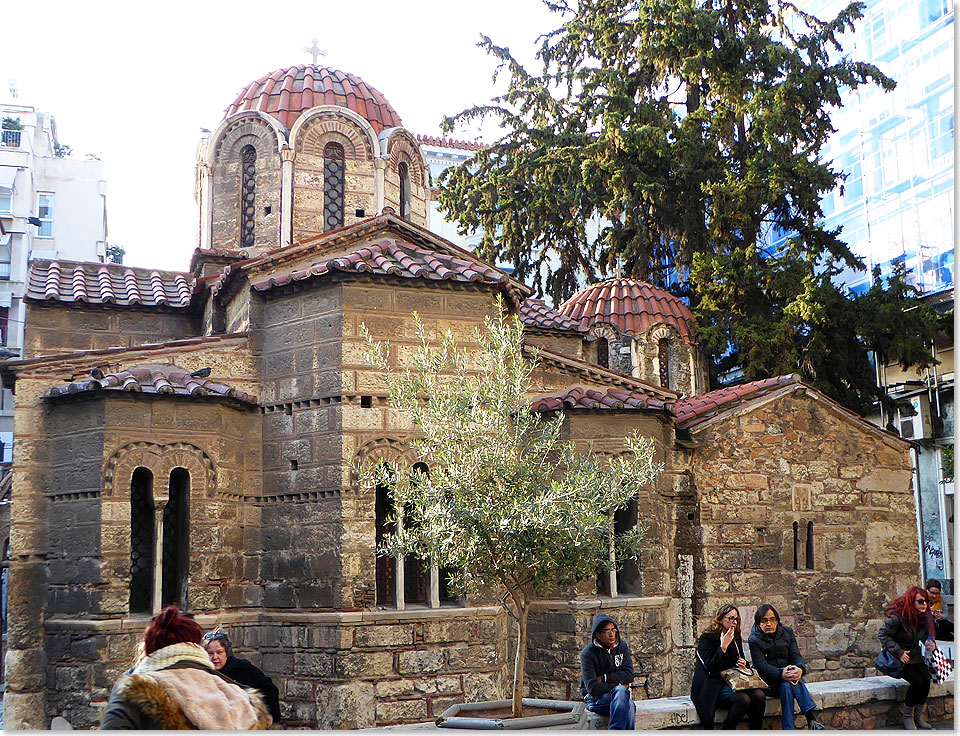 Winzig sieht sie aus, die kleine byzantinische Kirche Kapnikarea mitten in der Fußgängerzone der Innenstadt.  Athen wuchs auf den eigenen Trümmern höher. Die ständig genutzte Kirche, blieb auf dem alten Niveau und wirkt heute wie abgesunken.